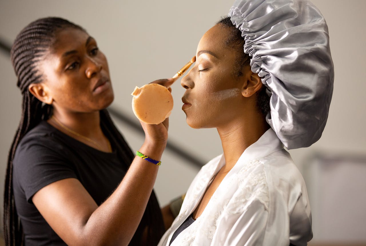 team-04 Makeup artist applying cosmetics to a client inside a salon.