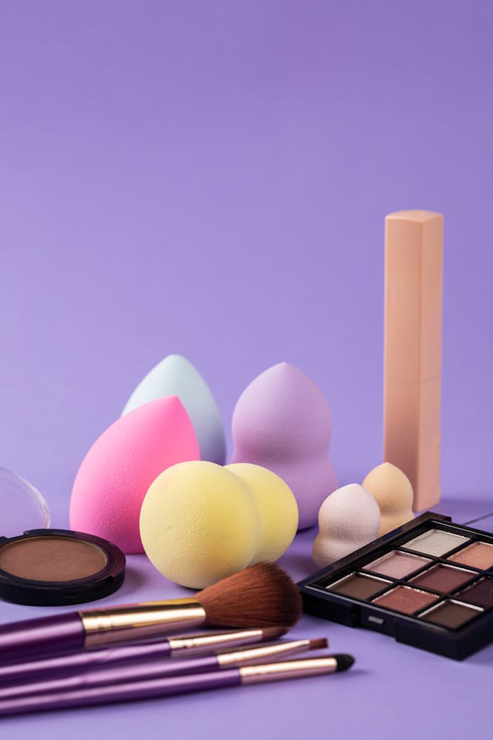 team-03 A collection of beauty blenders and makeup products on a purple background.